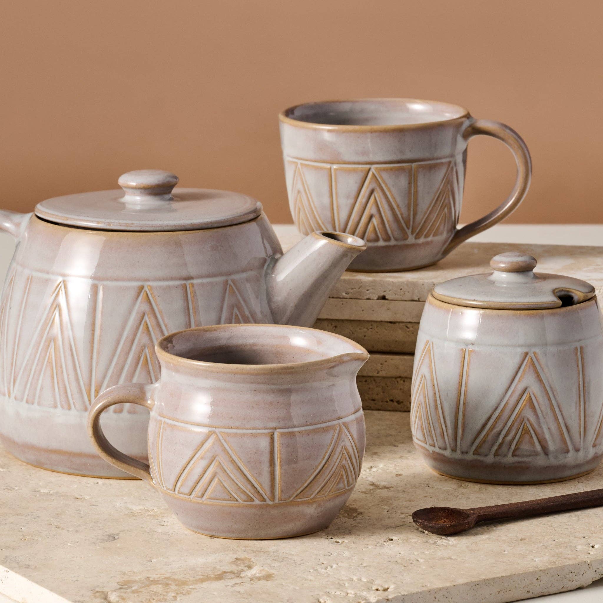 Ceramic tea set with geometric patterns on a wooden surface.