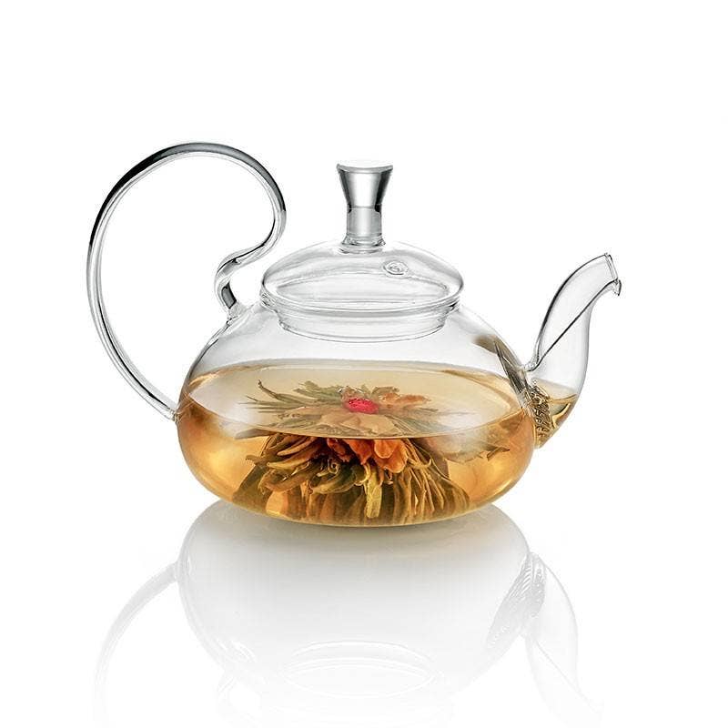 Clear glass teapot with floral tea on a white background