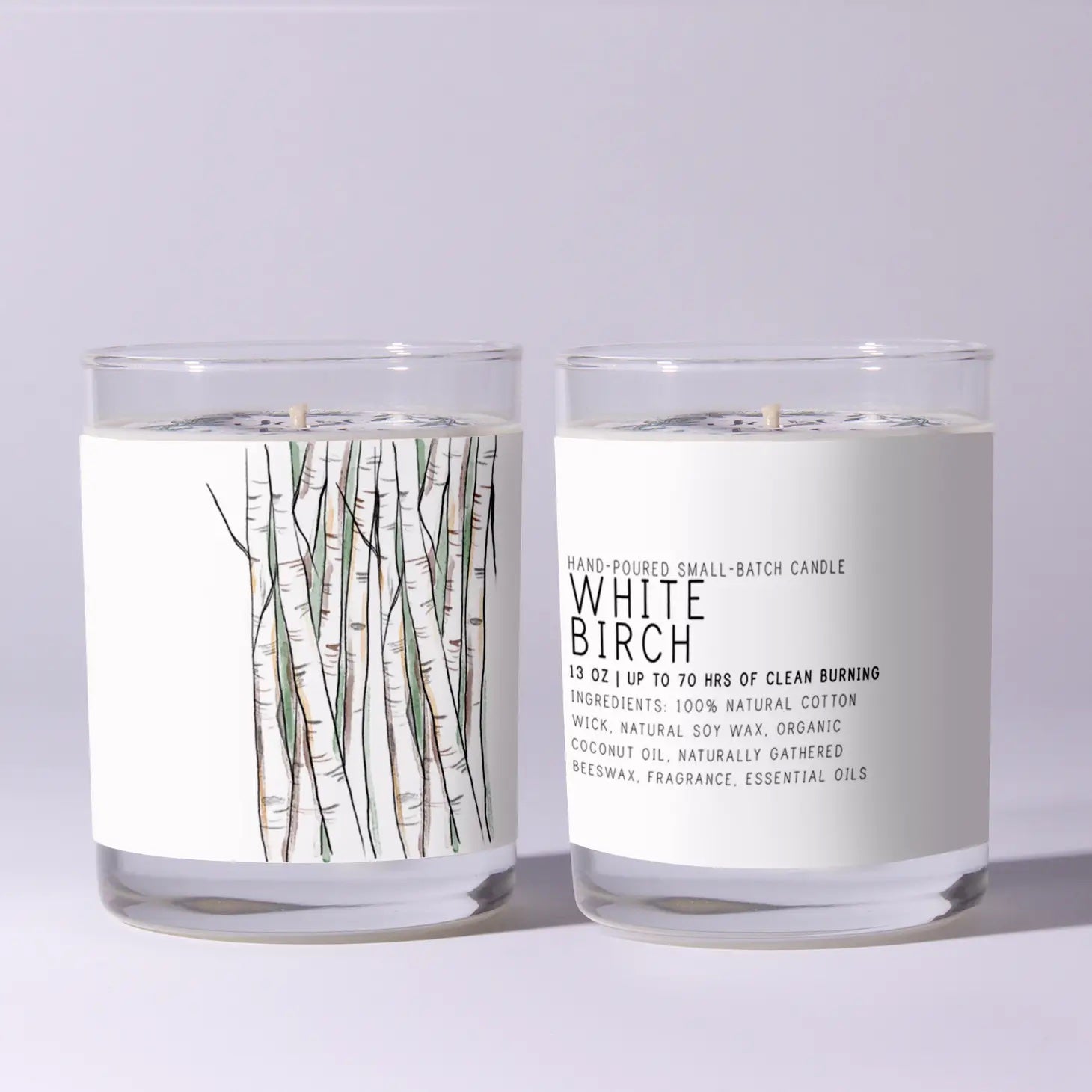Two White Birch candles with labels on a light gray background