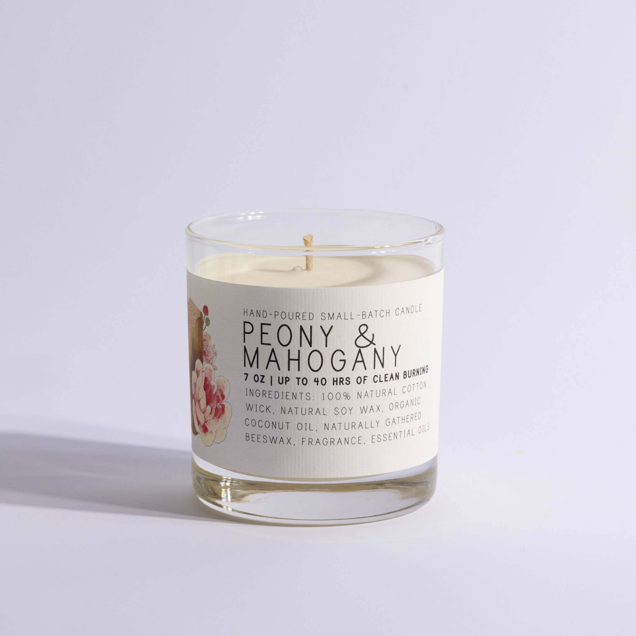Candle in a glass jar with a label on a light gray background