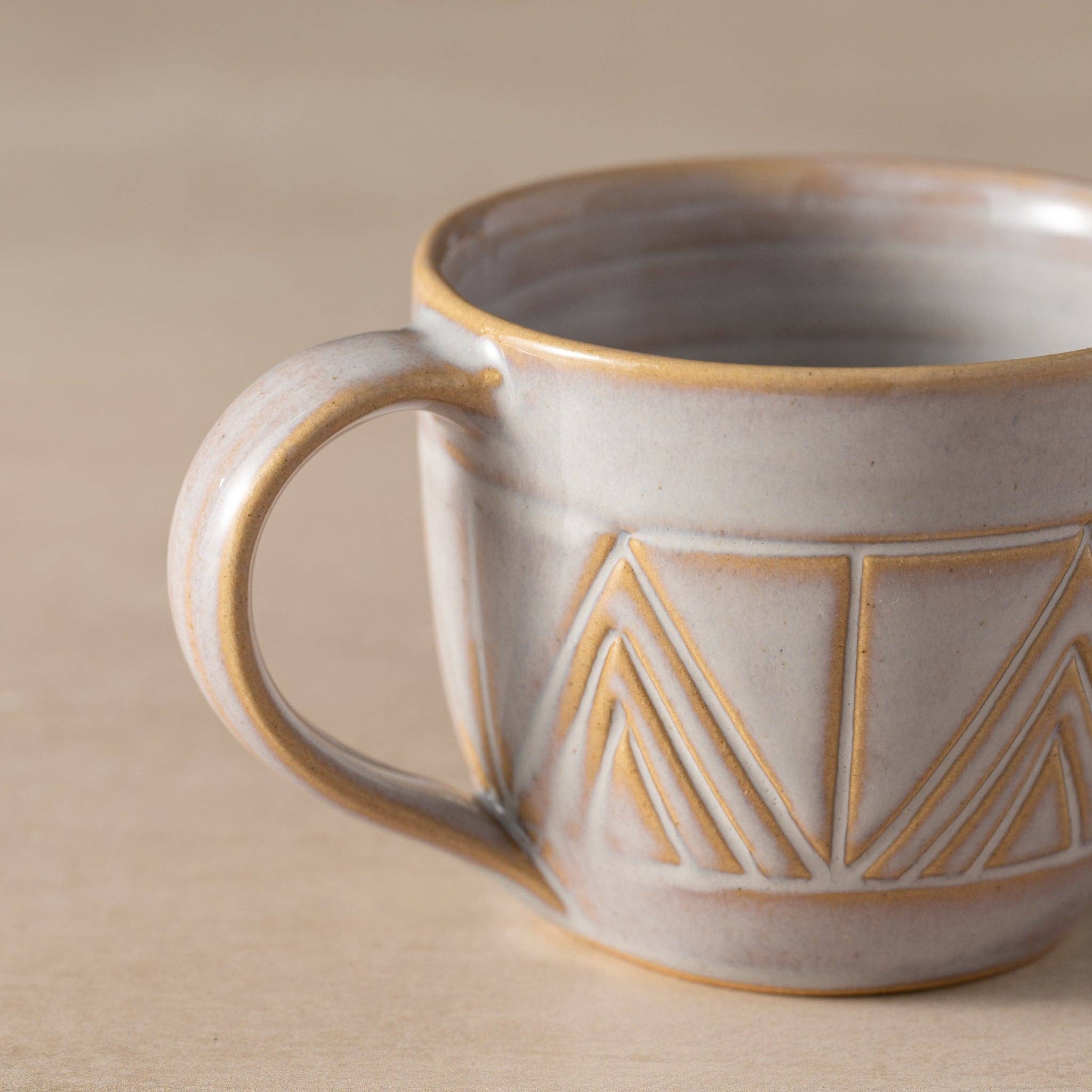 Ceramic mug with geometric pattern on a beige background