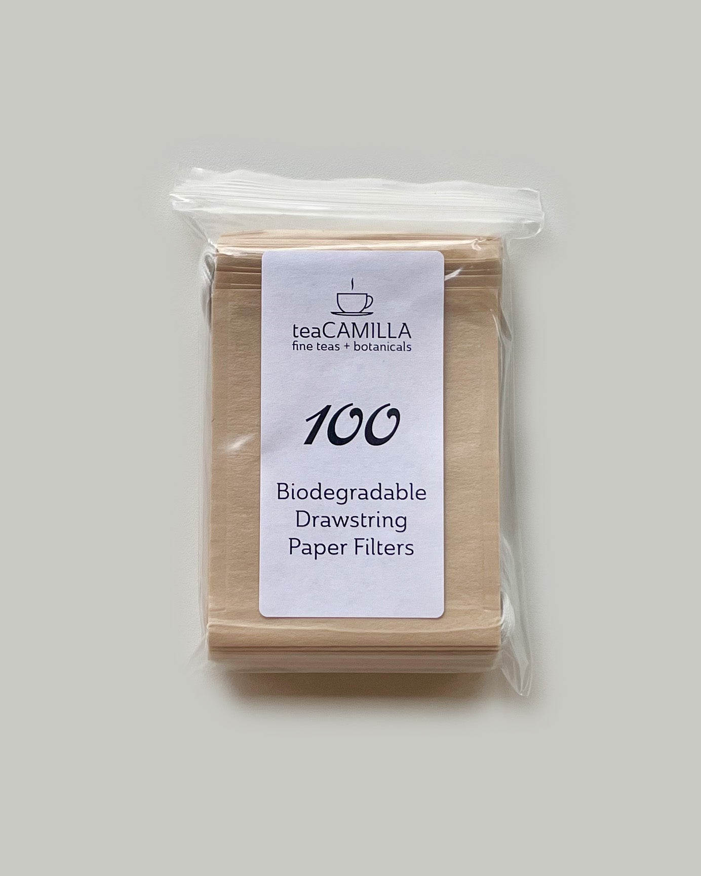 Pack of biodegradable drawstring paper filters with Tea Camilla branding on a plain background