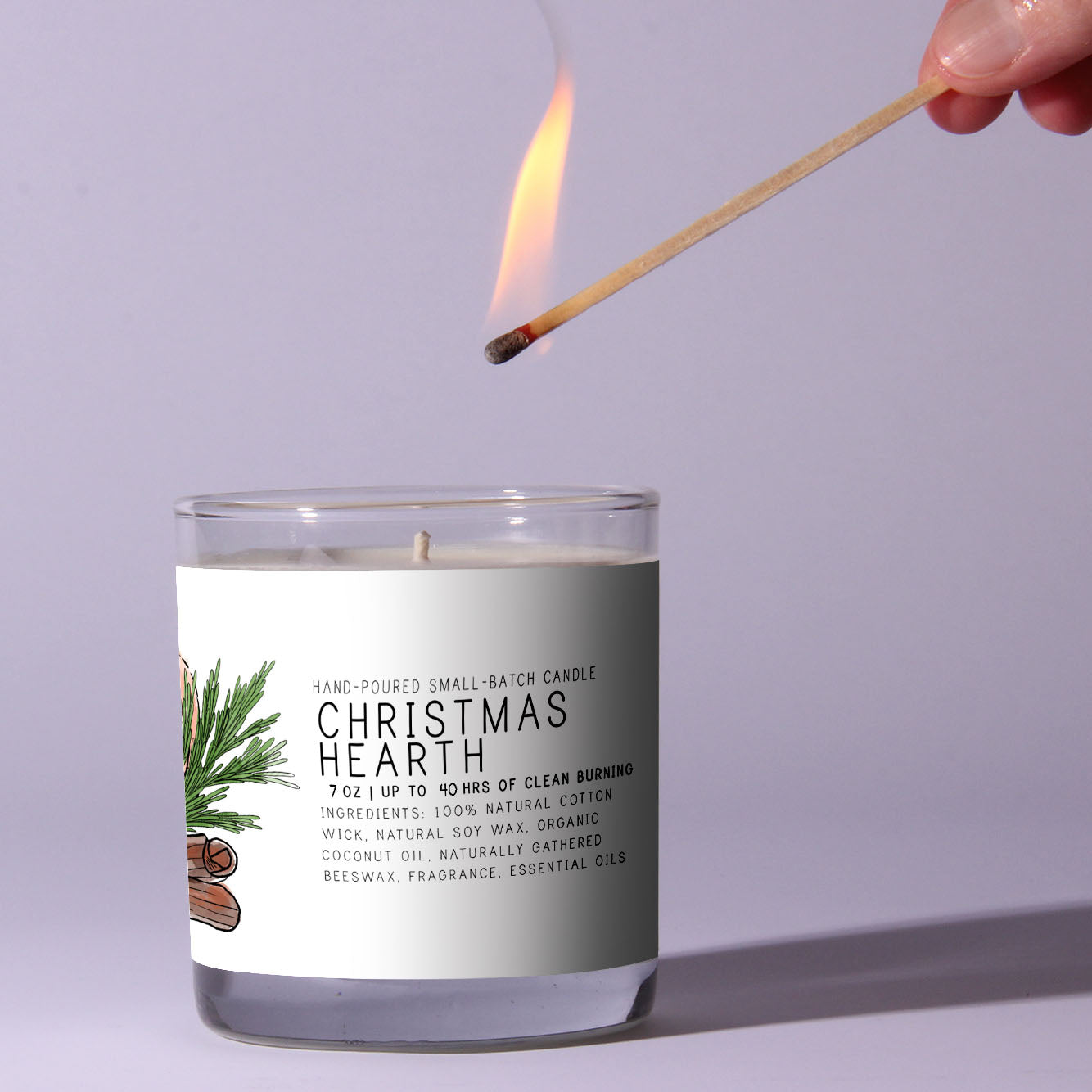 Candle labeled 'Christmas Hearth' being lit with a match against a light purple background