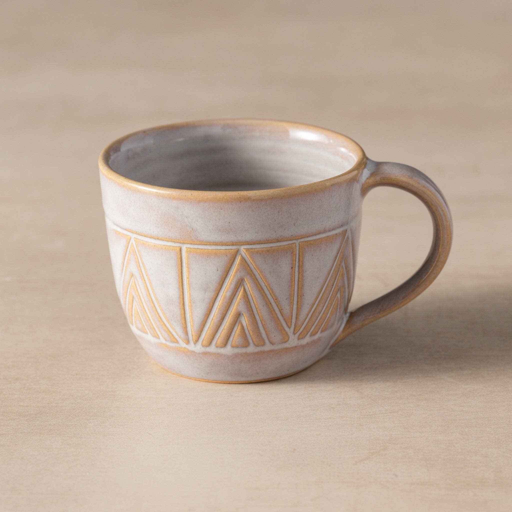 Ceramic mug with geometric pattern on a beige background