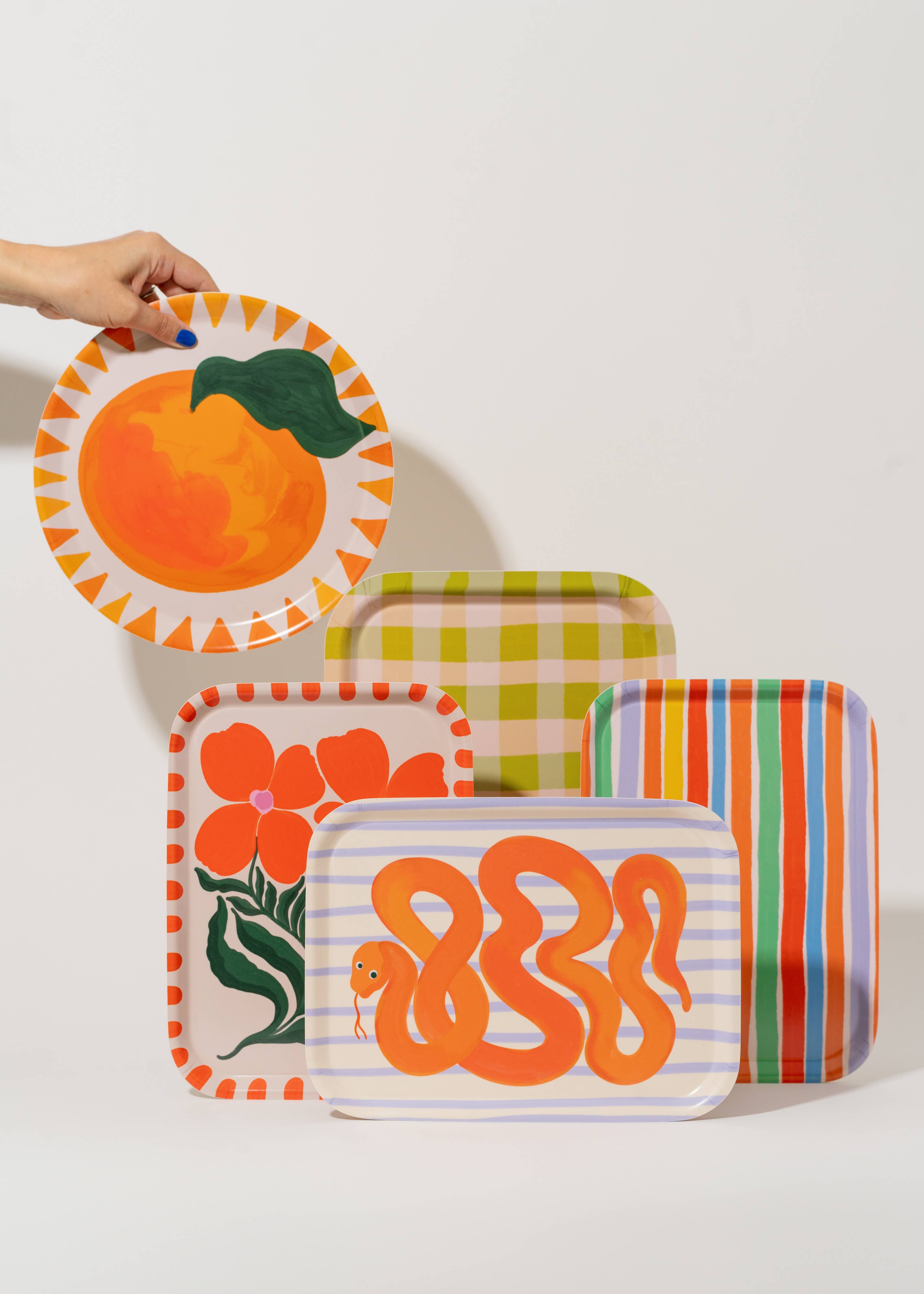 Set of colorful trays with floral, snake, and striped designs on a white background
