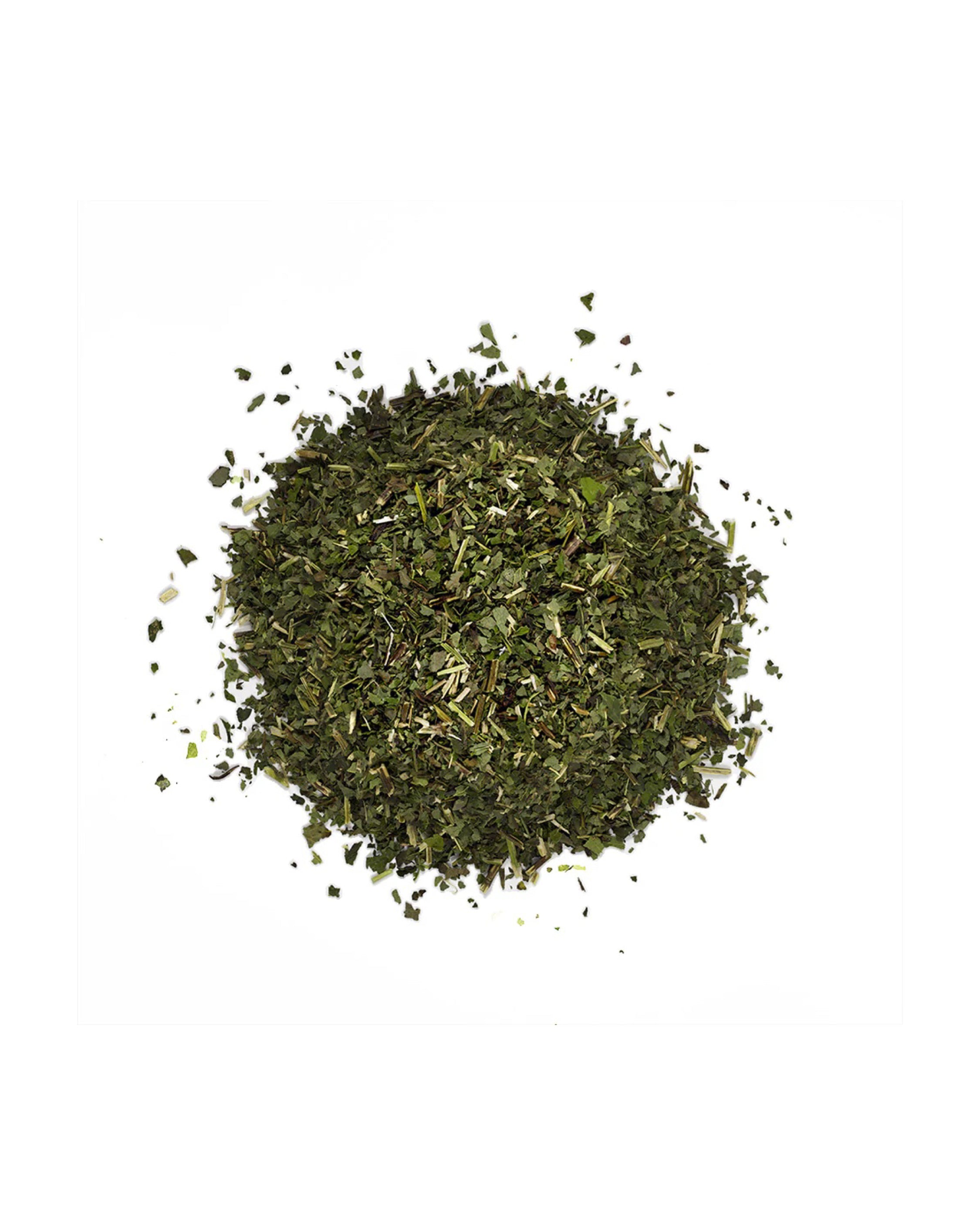 Pile of green dried herbs on a white background