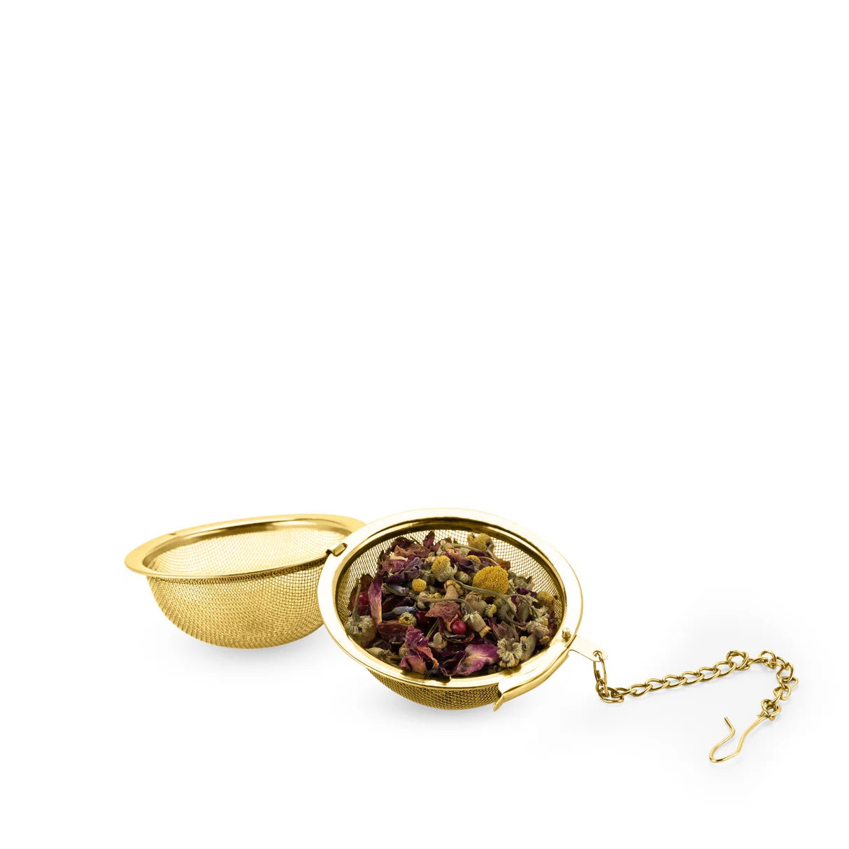 Gold tea ball infuser with dried tea leaves on a white background