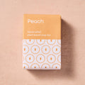 Handcrafted plant-based soap bar packaging with peach color on a beige background