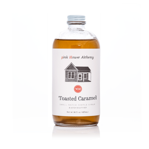 Bottle of Toasted Caramel syrup from pink House Alchemy on a white background