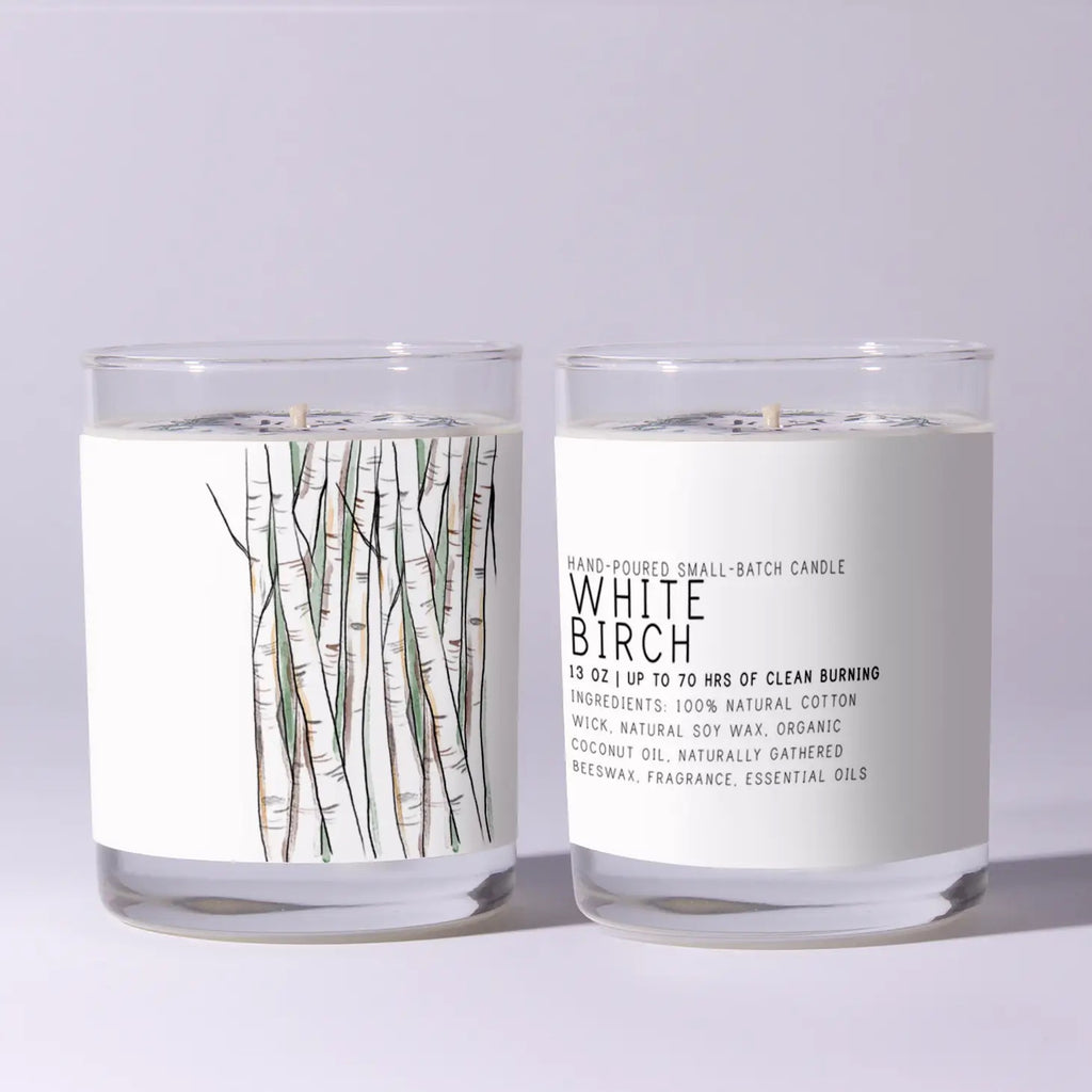 Two White Birch candles with labels on a light gray background