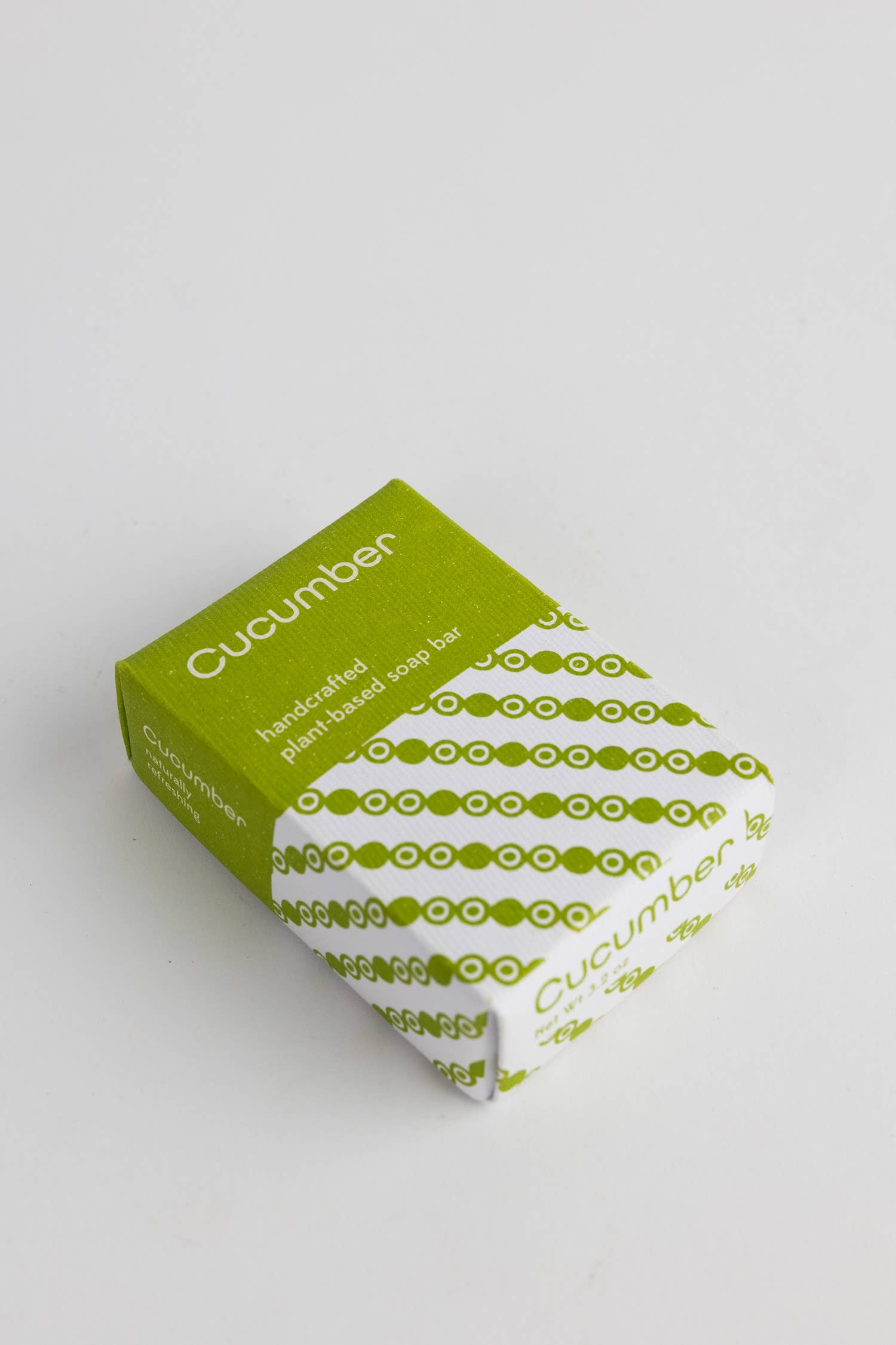 Cucumber soap bar with packaging on a light gray background
