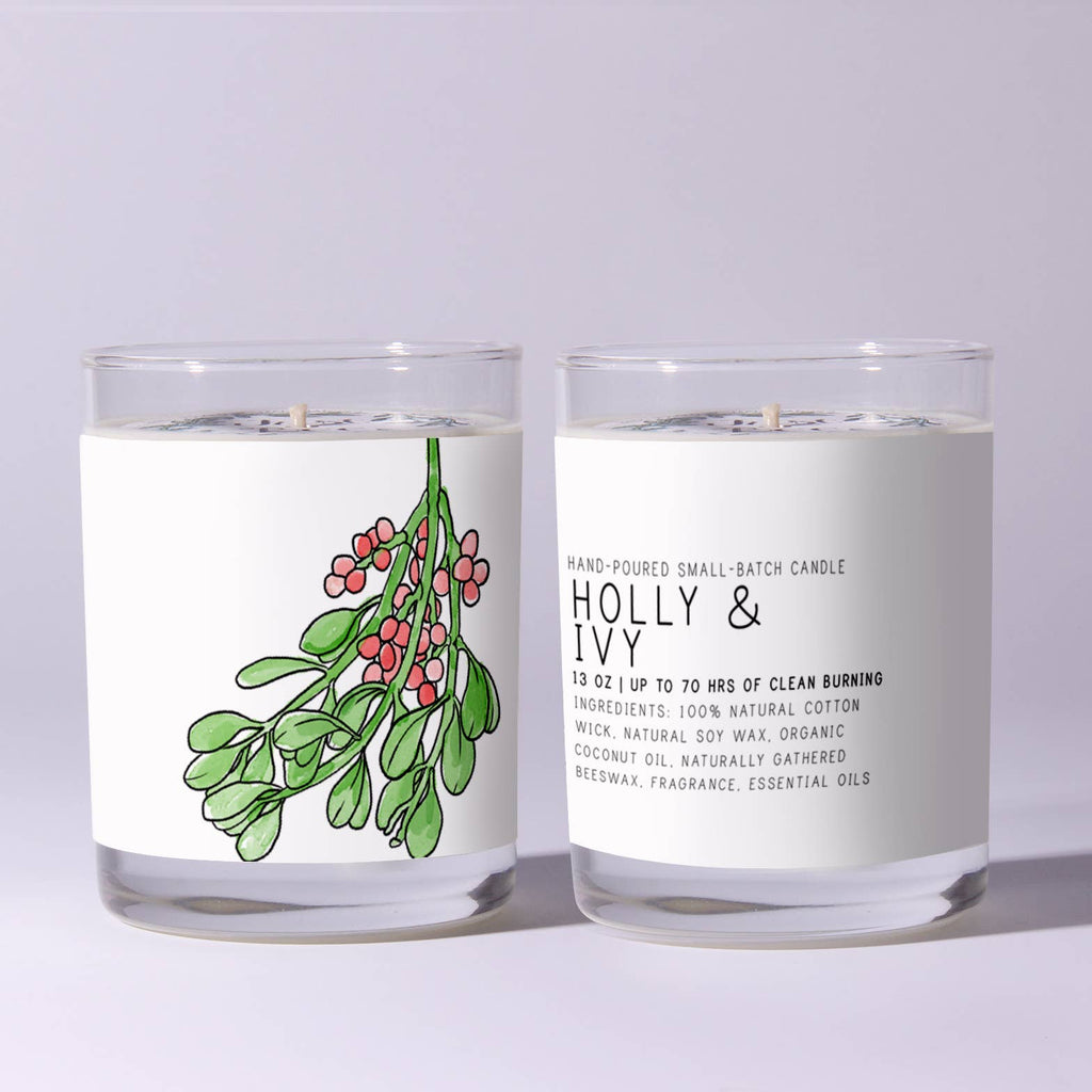 Two candles with labels featuring holly and ivy designs on a light gray background