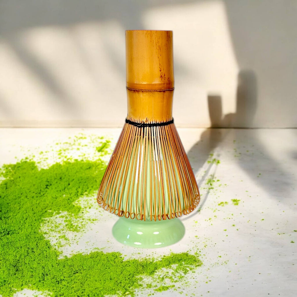 Bamboo whisk with green powder on a light surface