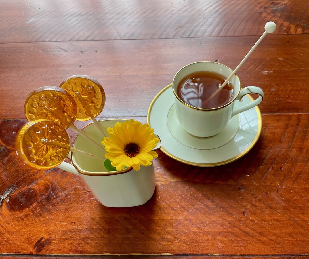 Teacup with lemon slices and a sunflower on a wooden surface