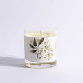 Candle in a glass jar with floral design on a light gray background