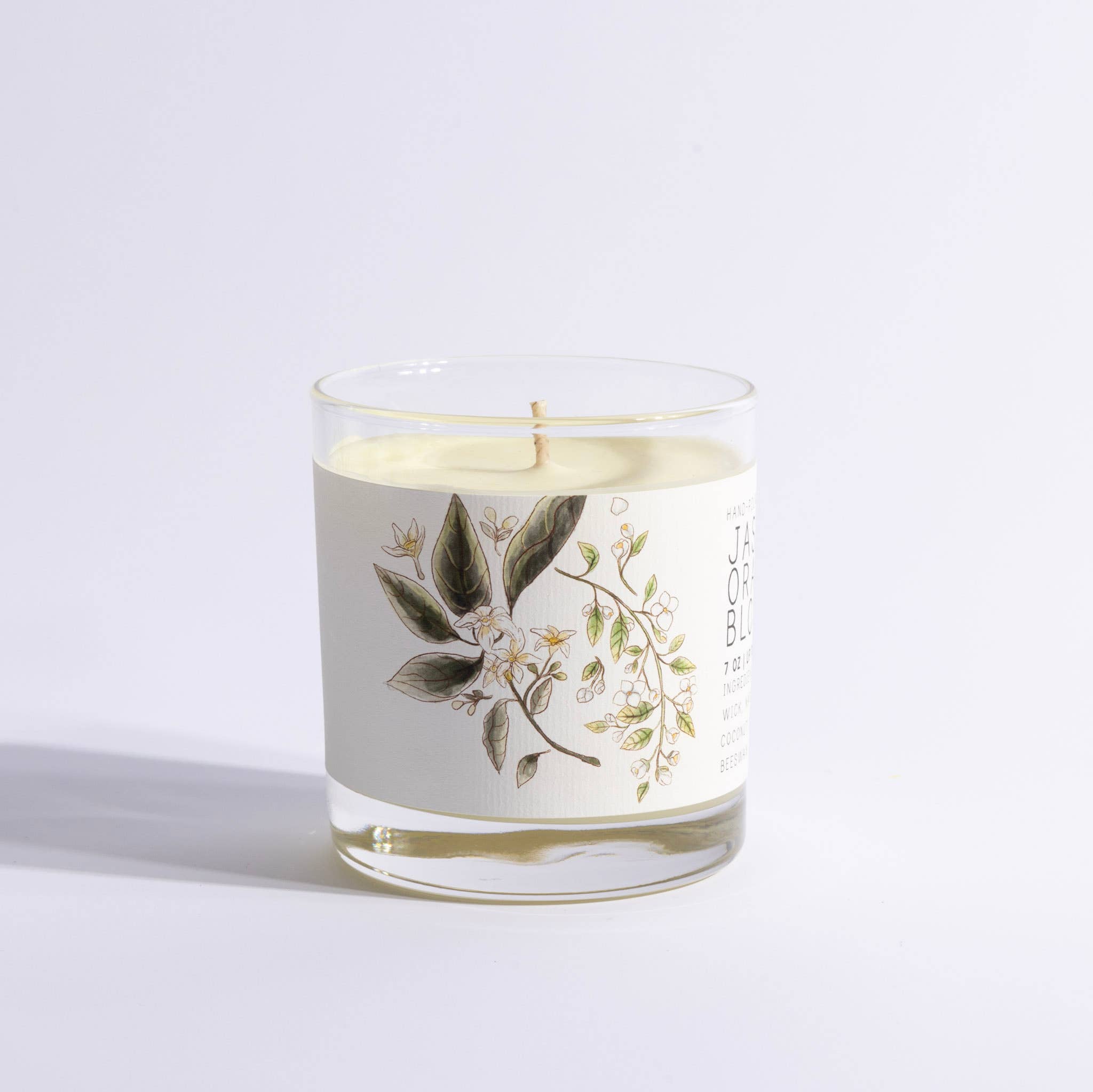 Candle in a glass jar with floral design on a light gray background