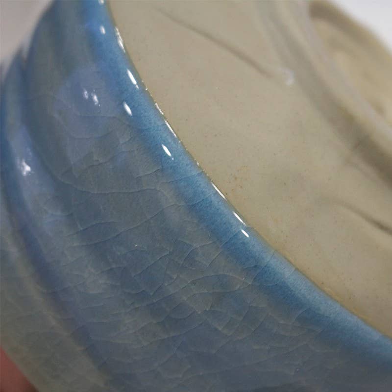 Close-up of a ceramic bowl with blue interior and beige exterior