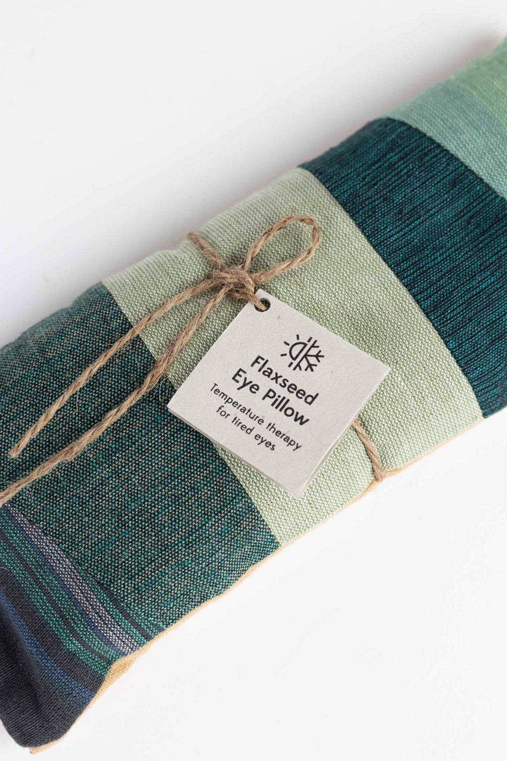 Green striped eye pillow with a label on a white background