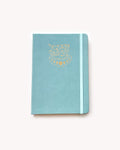 Light blue notebook with gold design on a white background