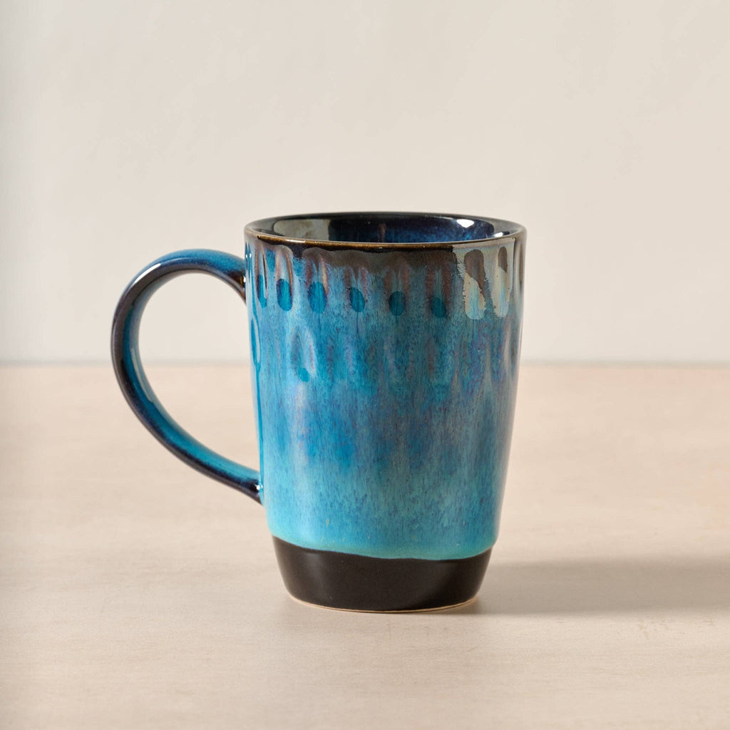 Blue ceramic mug on a beige surface