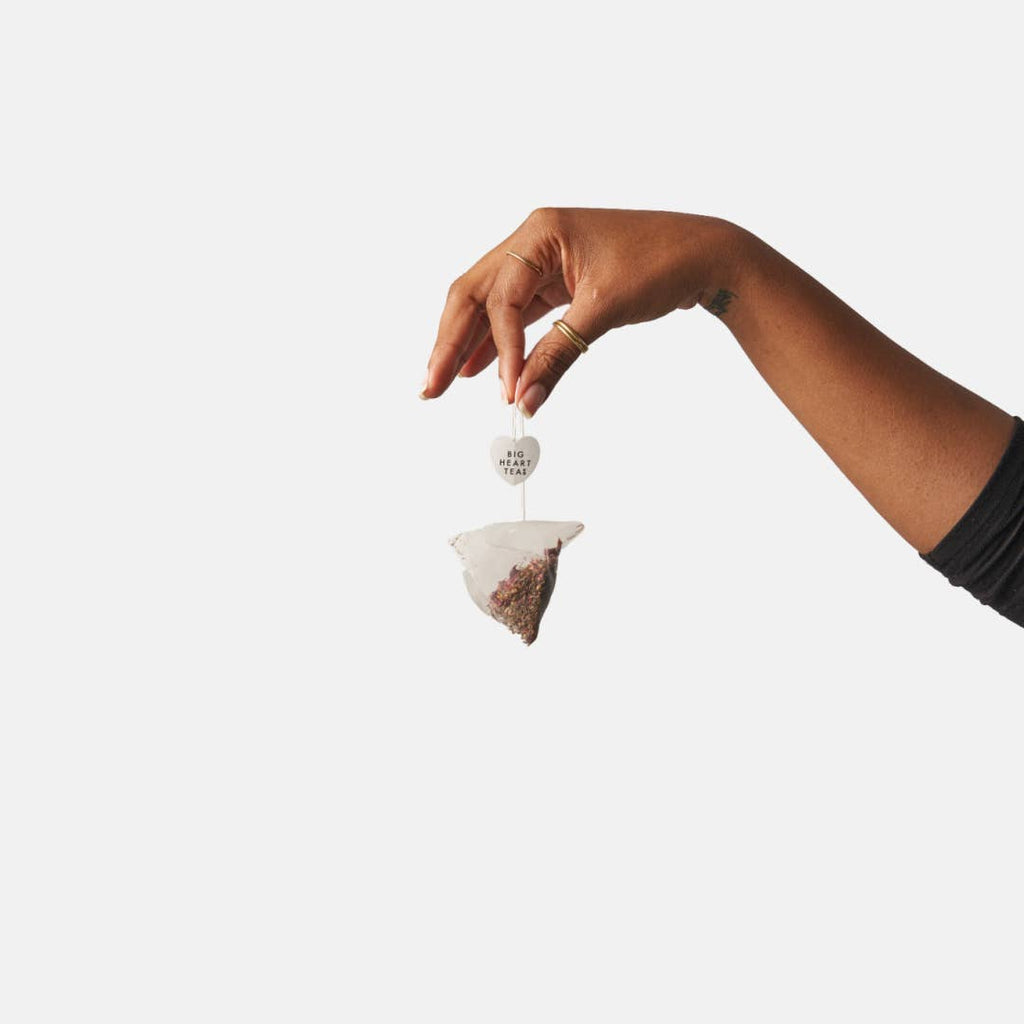 Hand holding a tea bag against a white background