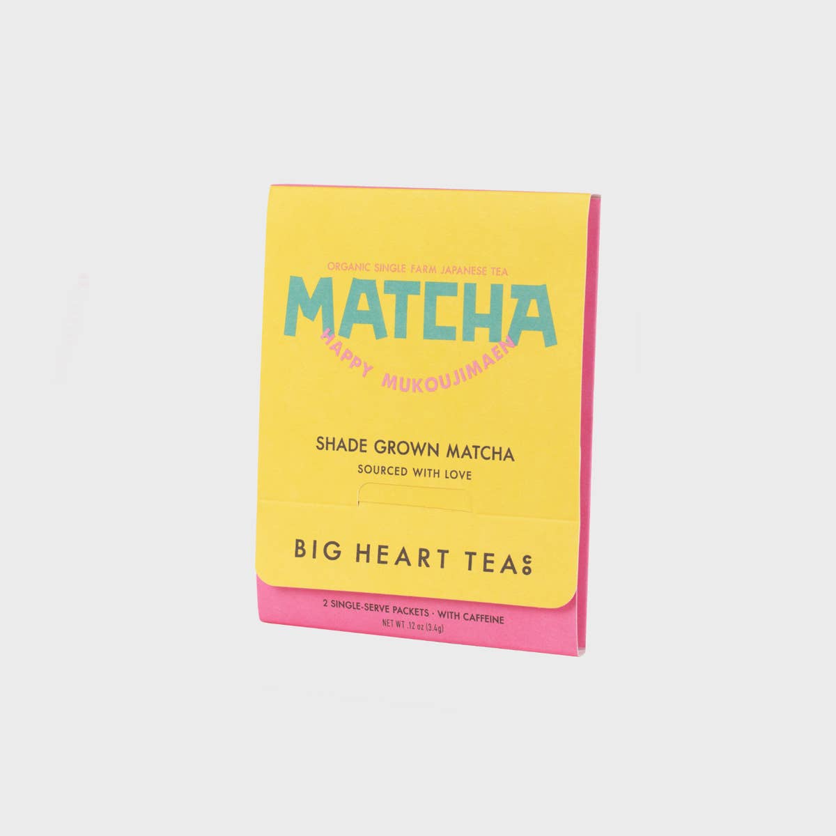Yellow and pink package of Big Heart Teas Matcha tea on a light gray background
