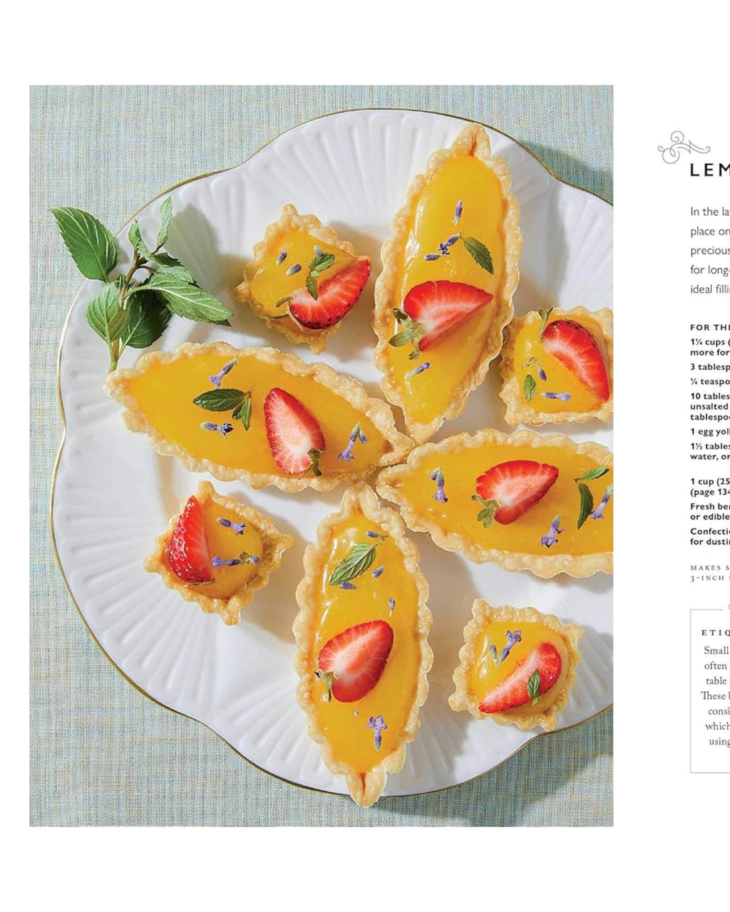 Lemon tarts with strawberries on a white plate with a light blue background