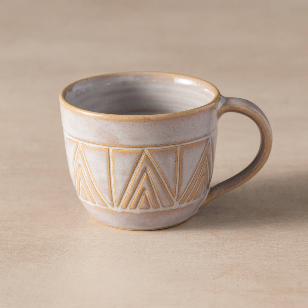 Ceramic mug with geometric pattern on a beige background