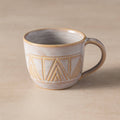 Ceramic mug with geometric pattern on a beige background
