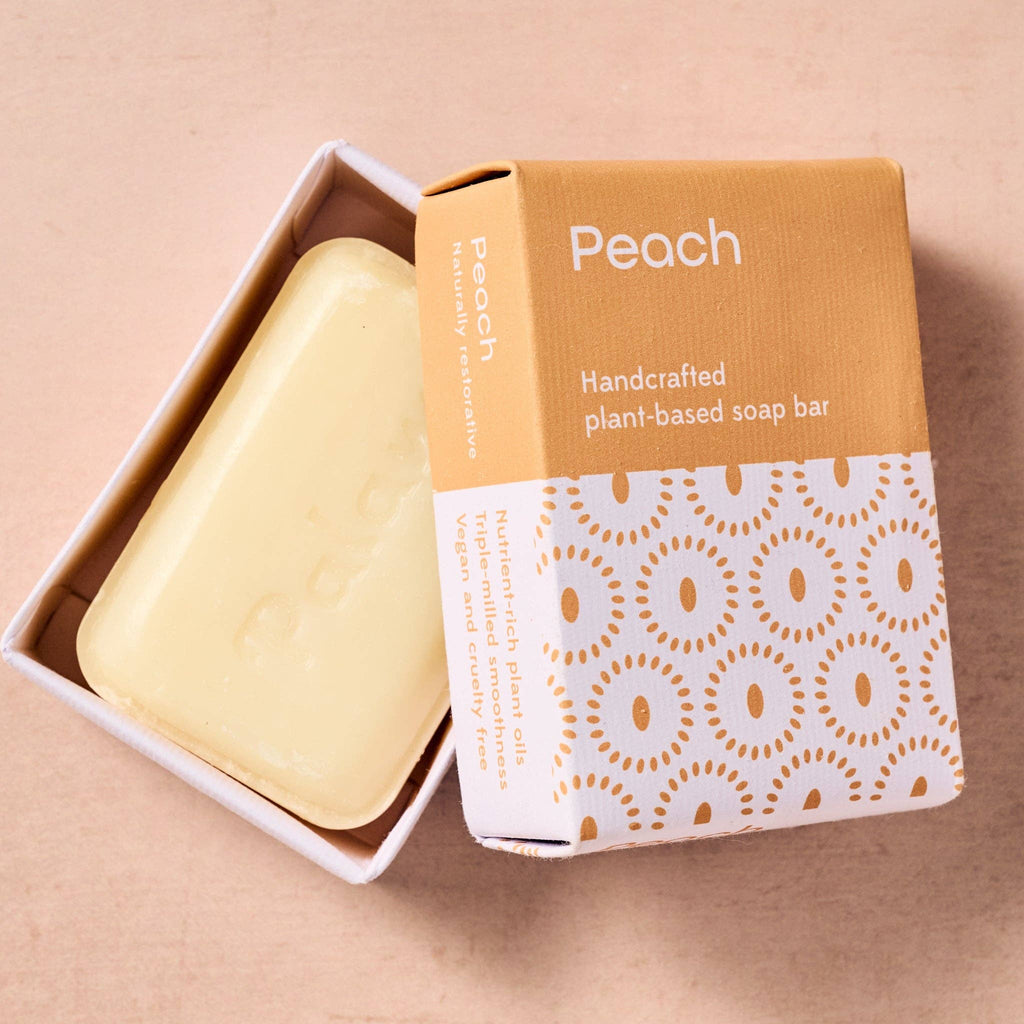 Handcrafted plant-based soap bar with packaging on a beige background