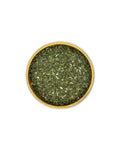 Bowl of dried green herbs on a white background