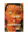 Book cover of 'The Tea Girl of Hummingbird Lane' by Lisa See with a woman's face and leaves on an orange background.