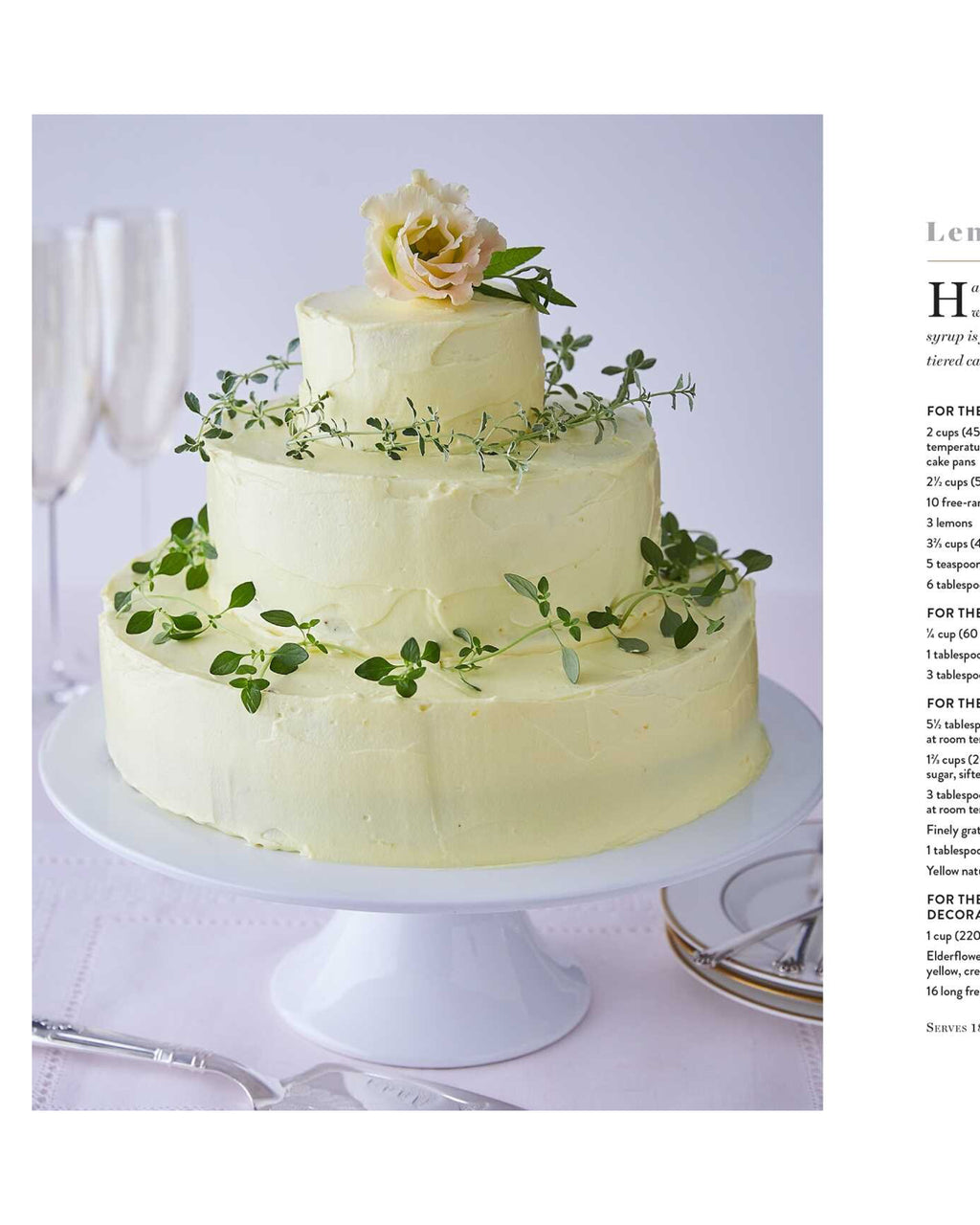 Three-tiered wedding cake with greenery and a flower on a white stand.