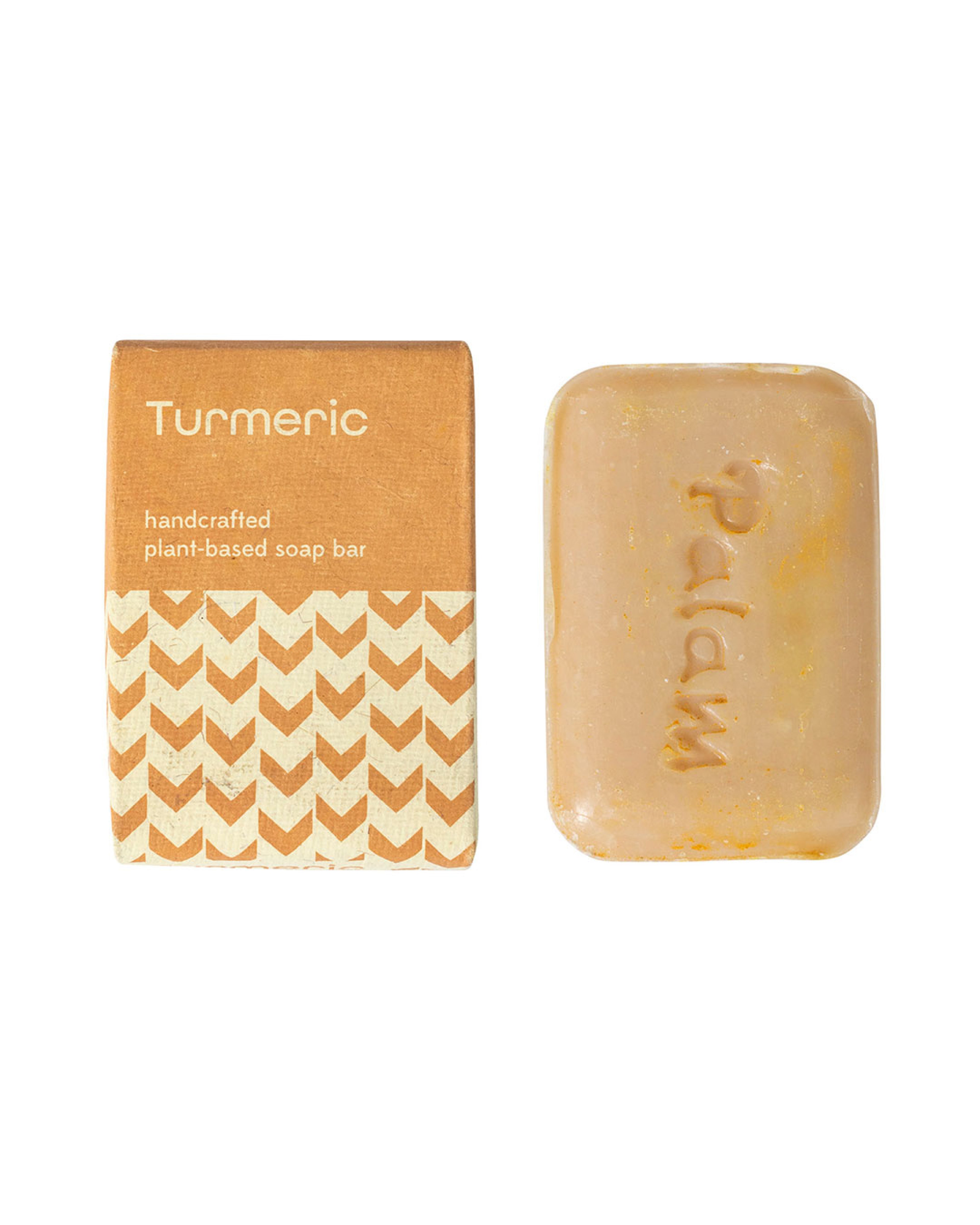 Handcrafted turmeric soap bar with packaging on a white background