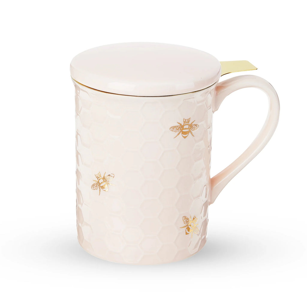Pink mug with gold bee designs on a white background